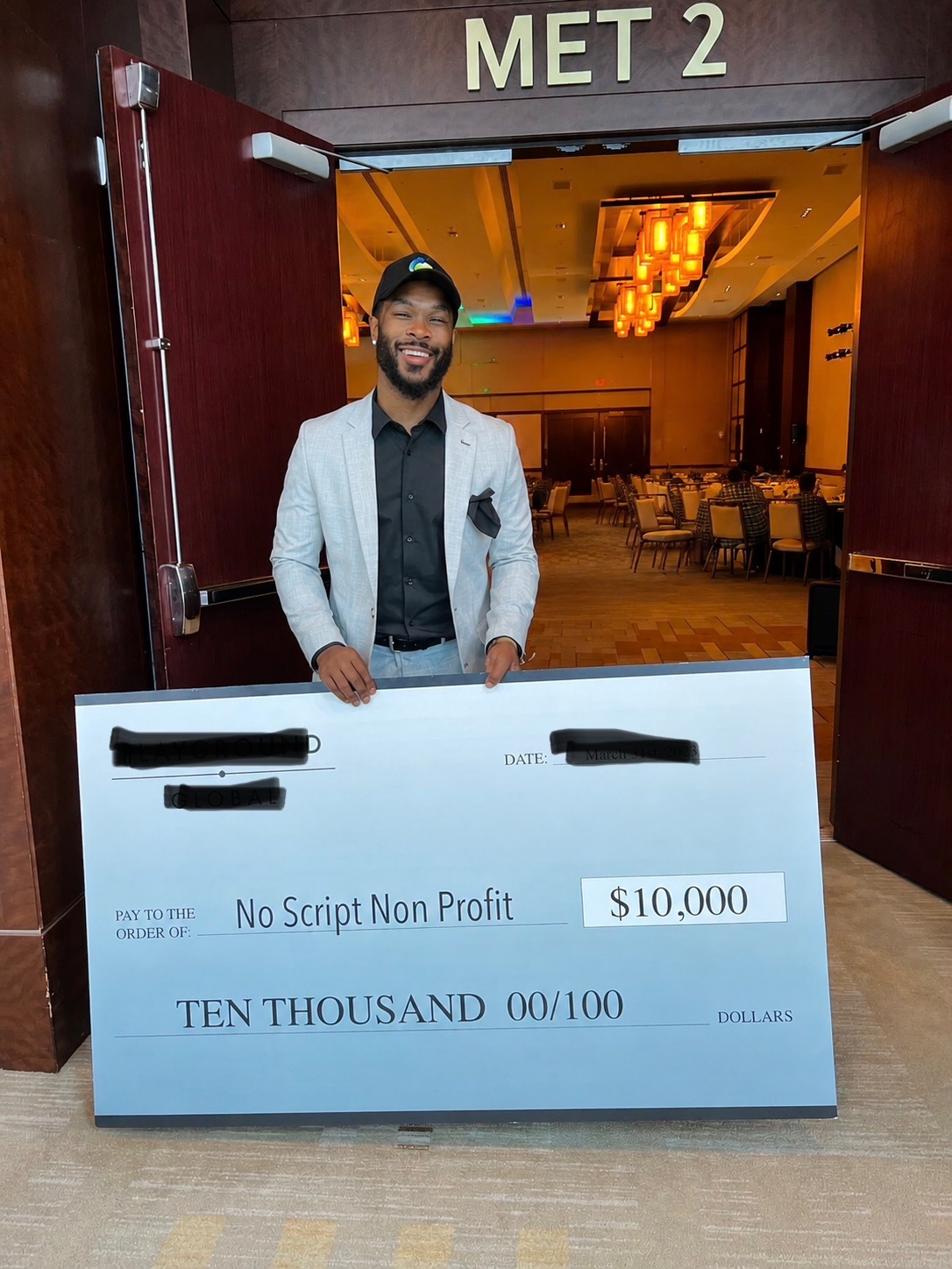 Brandon Johnson holding a ten thousand dollar donation check made out to No Script Non Profit