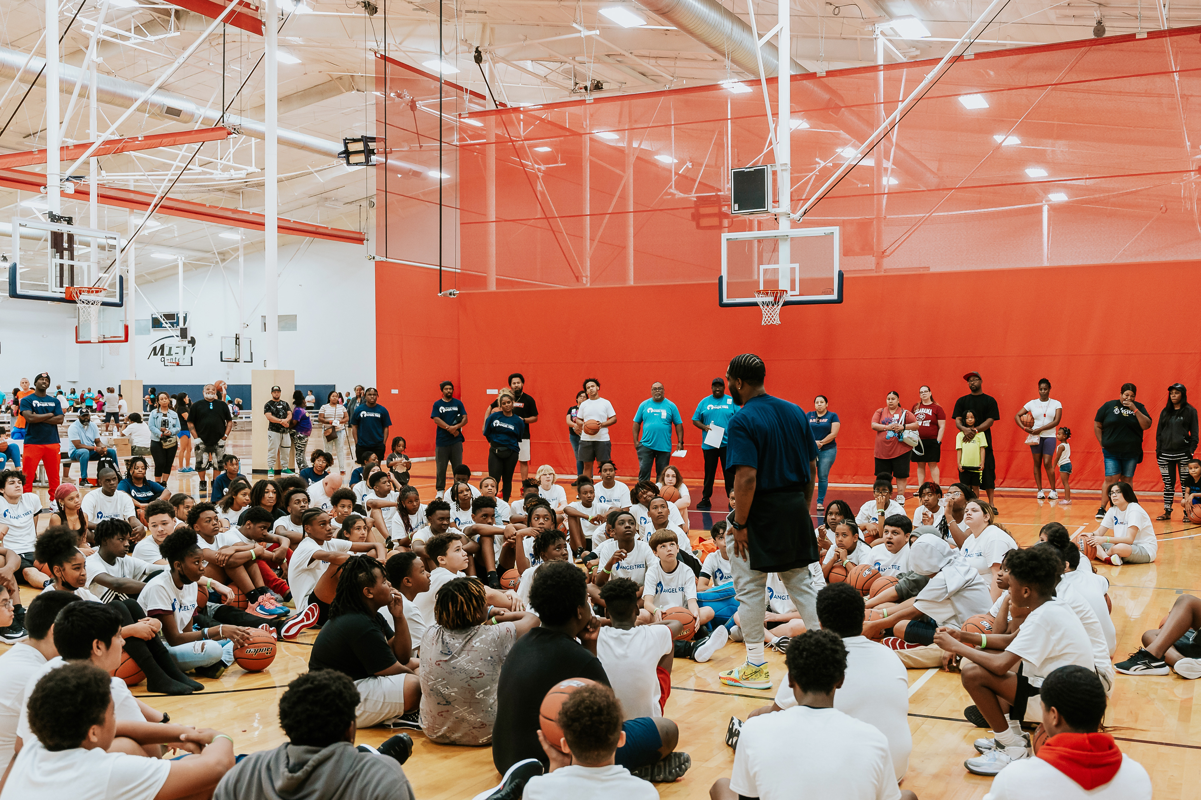 Brandon Johnson addressing a full gym of campers